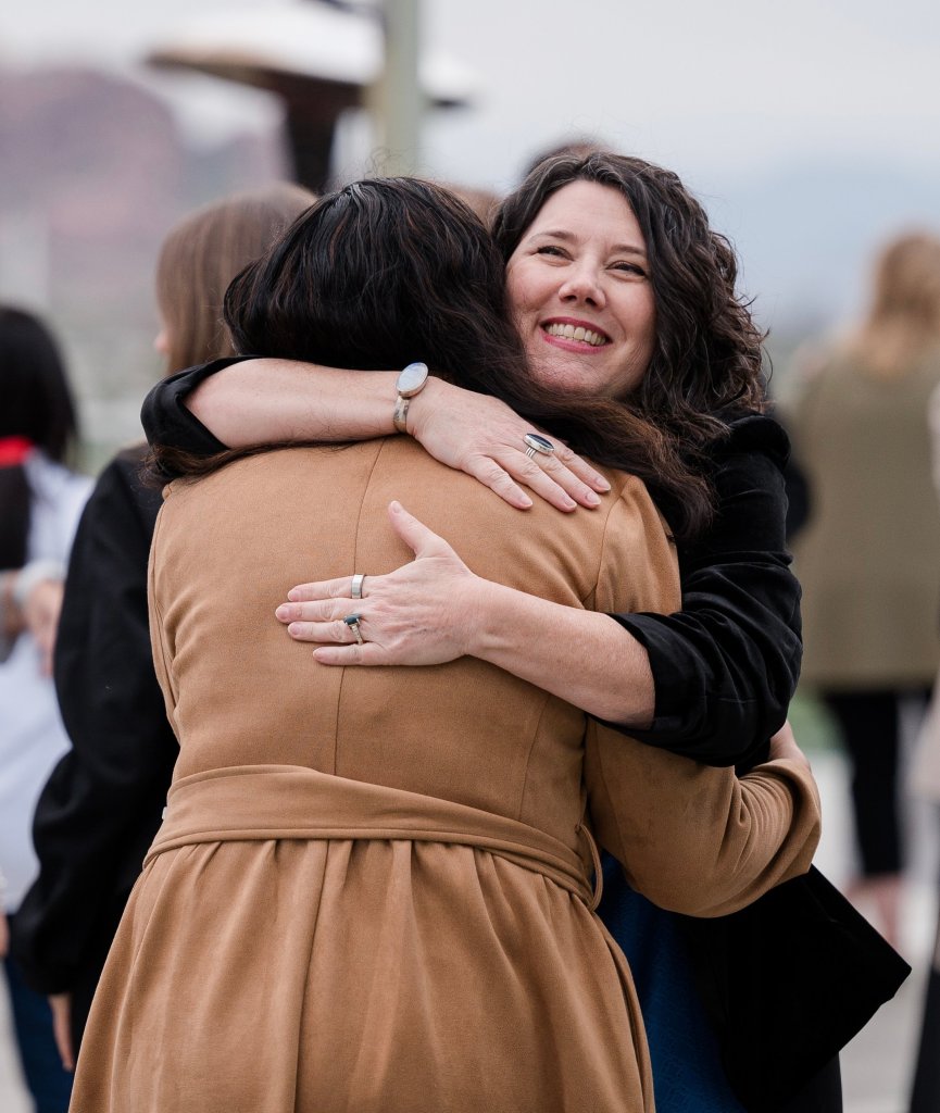 Su Zangara sharing a warm hug with a client at a women’s retreat